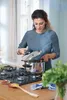 A woman is cooking with a pressure cooker on a gas stove. Náhled obrázku produktu