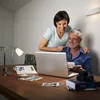 A couple looking at a laptop with photos on a table. Anteprima dell’immagine prodotto