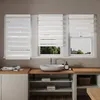 A bathroom vanity with a sink and a set of windows with blinds. Voir les images du produit