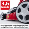 Close-up of a red lawnmower with large rear wheels, featuring a speed indicator and descriptive text. Produktbild-Vorschau