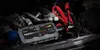 A car jump starter is shown in an engine bay. Podgląd zdjęcia produktu