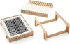 A disassembled Casus Grill, showing the charcoal briquettes, the grill grate, and the cardboard base. Produktbild-Vorschau