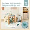 Two wooden activity cubes for babies are displayed on a light-colored rug. The background shows a shelf with folded blankets and a wall hanging. Produktbild-Vorschau