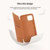 A brown leather flip case for a phone is shown open, with the inside of the case and the phone holder visible. The case is presented in a dynamic, almost floating manner, with white paper-like elements curving around it. Podgląd zdjęcia produktu