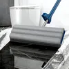 A mop head and handle are shown on a wet, tiled floor in front of a toilet. Voir les images du produit