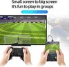 A handheld game console is shown connected to a large TV, with a controller in the foreground and the console in the midground. Produktbild-Vorschau