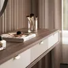 A close-up view of a modern console table with makeup brushes and a book on top, set against a backdrop of textured curtains. Produktbild-Vorschau