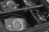 A close-up view of two black electronic devices with silver circular buttons and plus/minus symbols, stored inside a black padded bag with dividers. Náhľad obrázku produktu