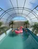 Children playing in a swimming pool covered by a transparent enclosure. Produktbild-Vorschau