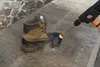 A brown boot is being cleaned with a pressure washer on a concrete surface. Náhled obrázku produktu