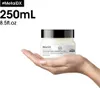 A hand holding a jar of L'Oréal Metal DX mask. Produktbild-Vorschau