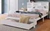 A white wooden bed frame with a bookshelf headboard and an open storage drawer, shown in a bedroom setting. Anteprima dell’immagine prodotto