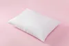 A white pillow is placed on a pink background. Produktbild-Vorschau