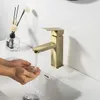 Hands washing under a gold faucet in a white sink. Náhľad obrázku produktu