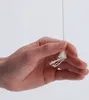 A hand holding a white pull cord for a ceiling clothes dryer. Produktbild-Vorschau