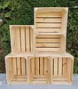 Wooden crates stacked in front of a green hedge. Produktbild-Vorschau