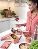 A woman is preparing food in a kitchen, with a lunchbox and various food items on a table. Podgląd zdjęcia produktu