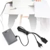 A sewing machine foot pedal and its power cord are shown on a white surface, with a blurred sewing machine and table in the background. Náhľad obrázku produktu