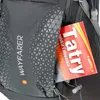 A close-up view of a backpack pocket with a map sticking out. Anteprima dell’immagine prodotto