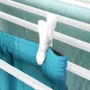 A close-up of a white clothespin holding a teal pair of shorts on a drying rack. Produktbild-Vorschau