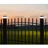 Two solar-powered fence post lights illuminate a black metal fence at dusk. Voir les images du produit