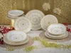 A collection of white and gold mandala-patterned plates and bowls are arranged on a table with a gold patterned background. Náhľad obrázku produktu