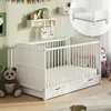A nursery room with a white crib, stuffed animals, and decorations on the wall. Produktbild-Vorschau