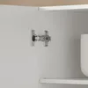 Close-up of a cabinet hinge on a white cabinet door. Náhled obrázku produktu
