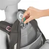 A hand is shown inserting a green component into a gray mechanism on a backpack. Produktbild-Vorschau