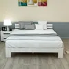 A white bed frame with white bedding and gray pillows is shown in a bedroom setting. Náhled obrázku produktu