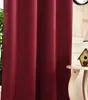 A close-up view of a burgundy curtain, with a small decorative birdhouse and a lamp visible on a table to the right. Produktbild-Vorschau