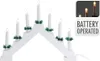 A white arched candle bridge with seven LED lights, decorated with green holly leaves. Podgląd zdjęcia produktu