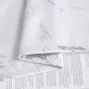 A close-up view of a white curtain with a silver marble-like pattern, partially covering a book. Produktbild-Vorschau