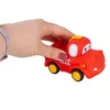 A hand holding a red toy fire truck. Produktbild-Vorschau