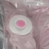 A close-up view of a pink vacuum storage bag with a white valve and a pink stopper. Produktbild-Vorschau