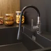 A close-up view of a modern kitchen sink with a black faucet with a flexible black spout and chrome accents. Anteprima dell’immagine prodotto