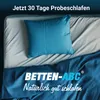 A neatly made bed with a blue pillow and blue bedding, with text overlay advertising a 30-day trial. Produktbild-Vorschau