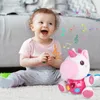 A baby is sitting on a carpet playing with a plush unicorn toy. Musical notes are floating around the baby and the toy, suggesting music and interaction. Anteprima dell’immagine prodotto