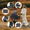 A woman pushing a stroller in an outdoor autumn setting. Produktbild-Vorschau