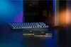 A computer setup with a keyboard and RAM sticks in the foreground, with a computer tower in the background. Anteprima dell’immagine prodotto