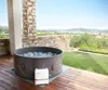 An inflatable hot tub is set up on a wooden deck overlooking a scenic landscape with hills and buildings. Náhled obrázku produktu