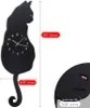 A black cat-shaped wall clock with dimensions indicated by measurement lines and text overlays. Produktbild-Vorschau