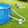 A round blue swimming pool with a filter pump system set up on a green lawn. Náhled obrázku produktu