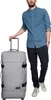 A man stands next to a large gray suitcase. Produktbild-Vorschau