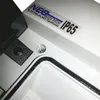 A close-up view of a white electrical enclosure with a black rubber seal and a label indicating IP65 rating. Produktbild-Vorschau