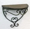 A wall shelf with a wooden top and decorative metal scrollwork. Produktbild-Vorschau