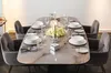 A dining table set for a meal with place settings and a floral centerpiece. Voir les images du produit