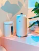 Three white kitchen canisters and a paper towel holder are arranged on a pink surface with a plant in the background. Produktbild-Vorschau