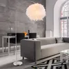 A modern living room with a sofa, coffee table, and a floor lamp. Produktbild-Vorschau