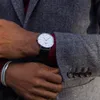 A close-up shot of a person's wrist wearing a watch and bracelet, with part of a jacket visible. Voir les images du produit